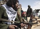 Defected Libyan soldiers and volunteers cheer as they sit on the outskirts of the eastern town of Brega, Libya, Thursday, March 3, 2011. Mutinous army units in pickup trucks armed with machine-guns and rocket launchers deployed around the strategic oil installation at Brega Thursday, securing the site after the opposition repelled an attempt by loyalists of Moammar Gadhafi to retake the port in rebel-held east Libya. (AP Photo/Tara Todras-Whitehill)