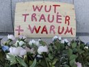 Flowers and a sign reading 'anger, grief, why' are put down at the site where a two US airmen have been killed in front of the Frankfurt, Germany, airport, Thursday, March 3, 2011. German federal prosecutors said Wednesday's attack on a busload of U.S. airmen that killed two and wounded two others at Frankfurt airport appears to have been motivated by Islamic extremism. (AP Photo/Michael Probst)